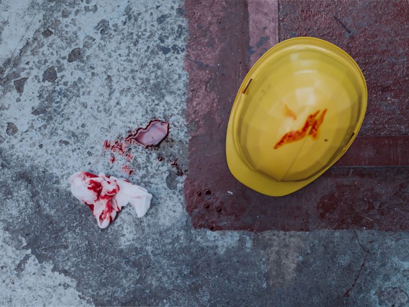Helmet and tissue with blood stains and blood on the floor, work accident concpet. Helmet and tissue with blood stains and blood on the floor, work accident concpet.