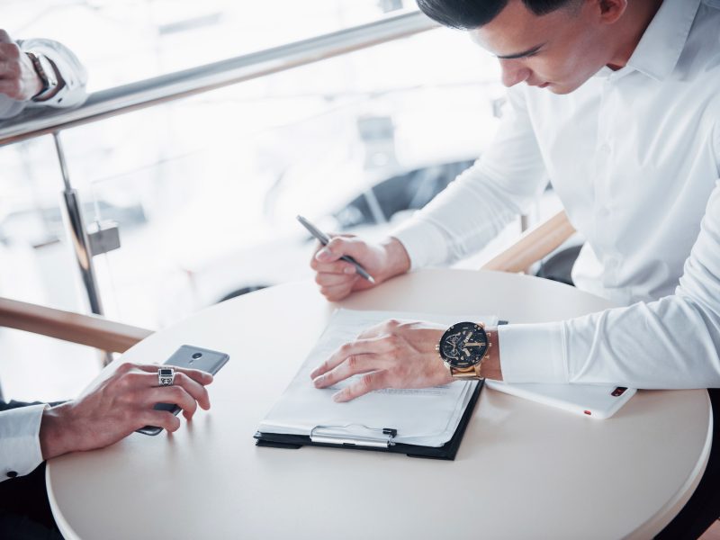 Young man signs documents in the office, successful sales Young man signs documents in the office, successful sales